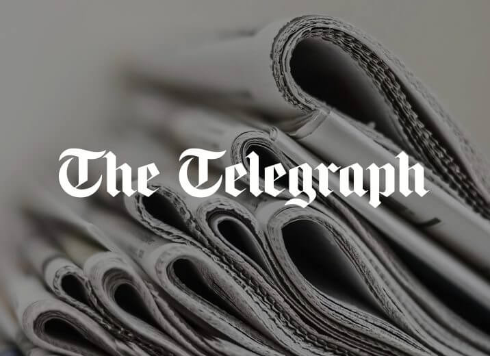 Stacked newspapers with The Telegraph logo in the middle