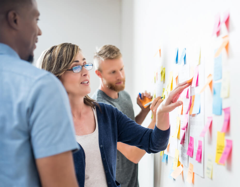 Team collaborating at a board using sticky notes