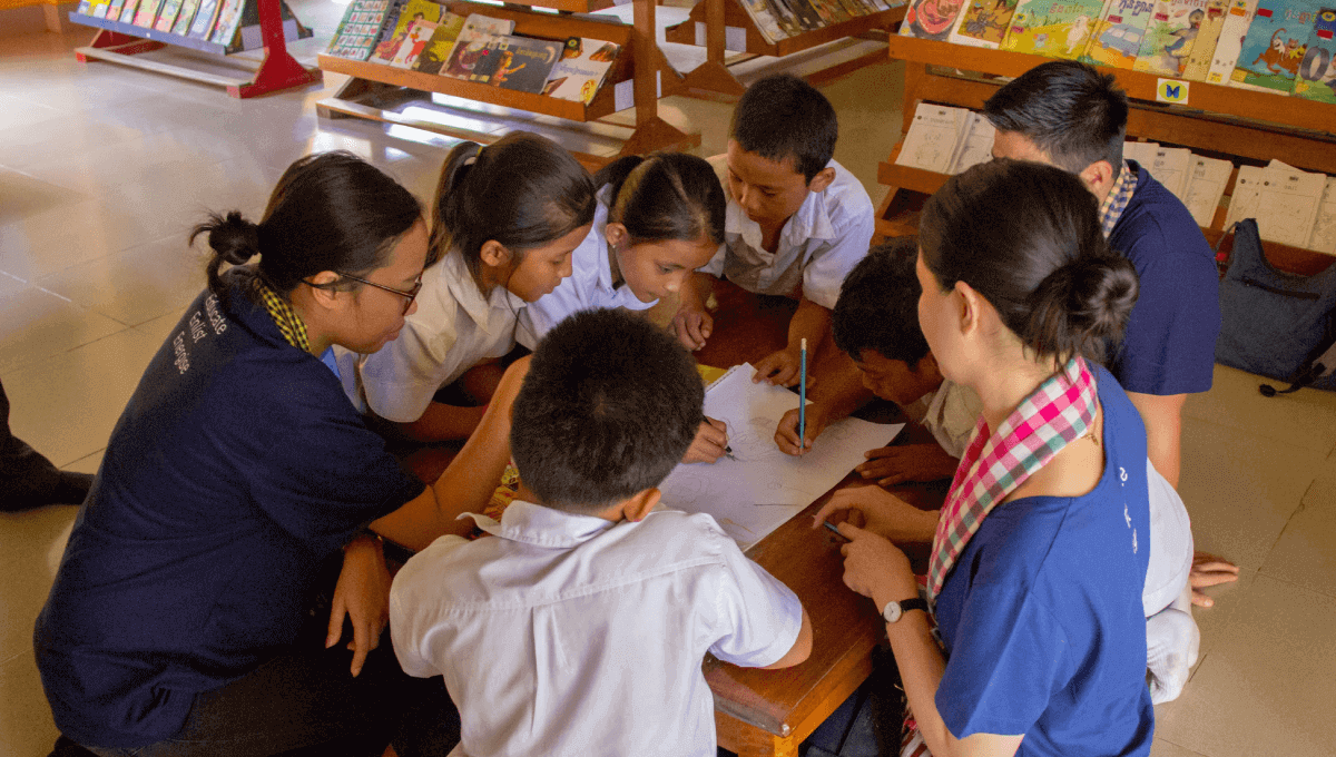 3 Atlassian volunteers with Room to Read to students in Cambodia