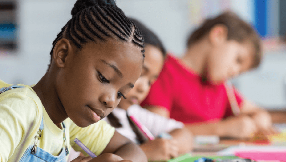 Three students in class are focused on learning