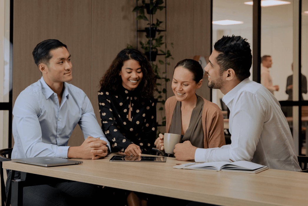 Quatro colegas de trabalho colaborando em uma mesa de café