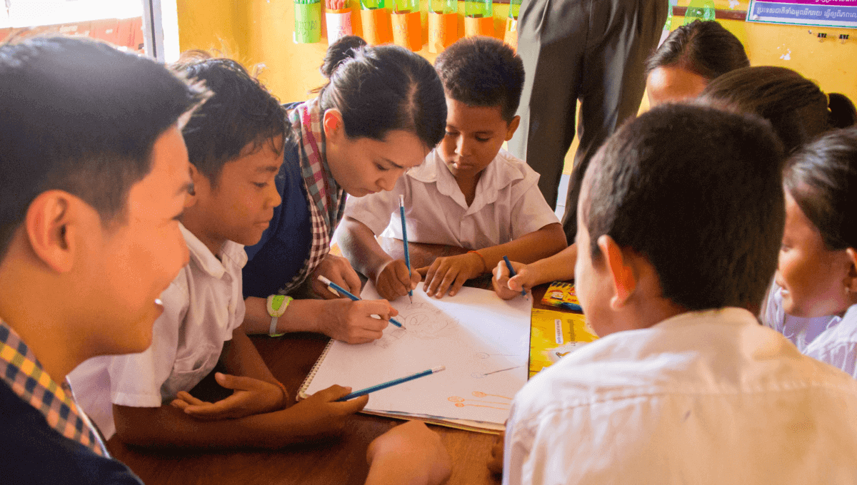 3 Atlassian volunteers with Room to Read to students in Cambodia